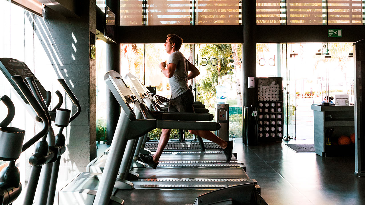 Un hombre corriendo en cintas de correr en un gimnasio