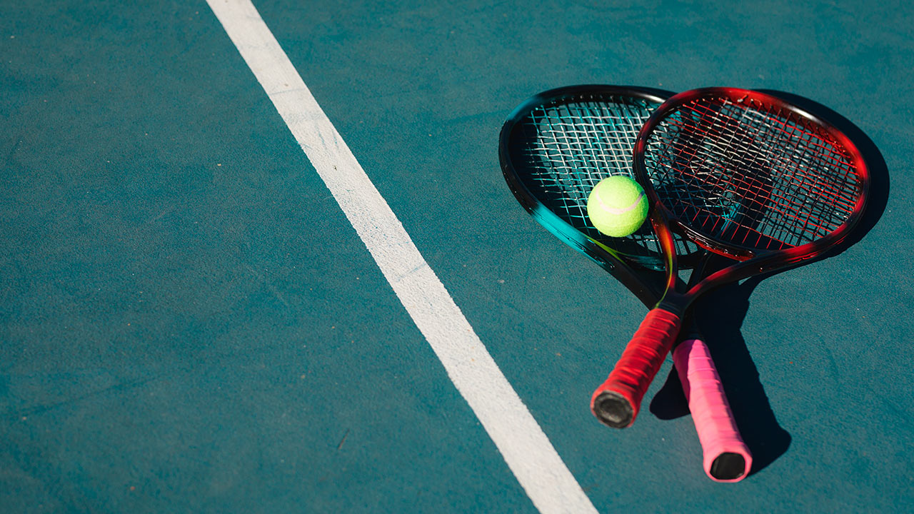 a tennis rackets and a ball on a court