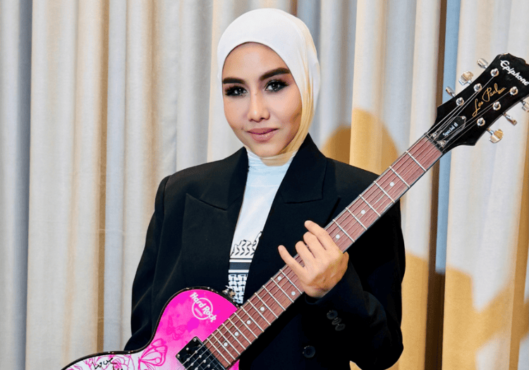 a woman in a black suit holding a pink guitar