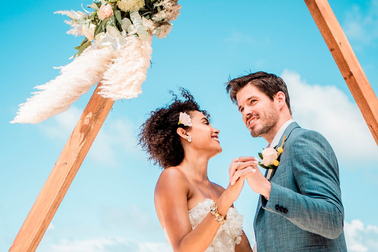 a man and woman holding hands under an arch