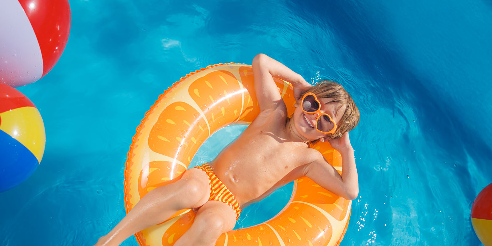a boy in a swimsuit on a float in a pool