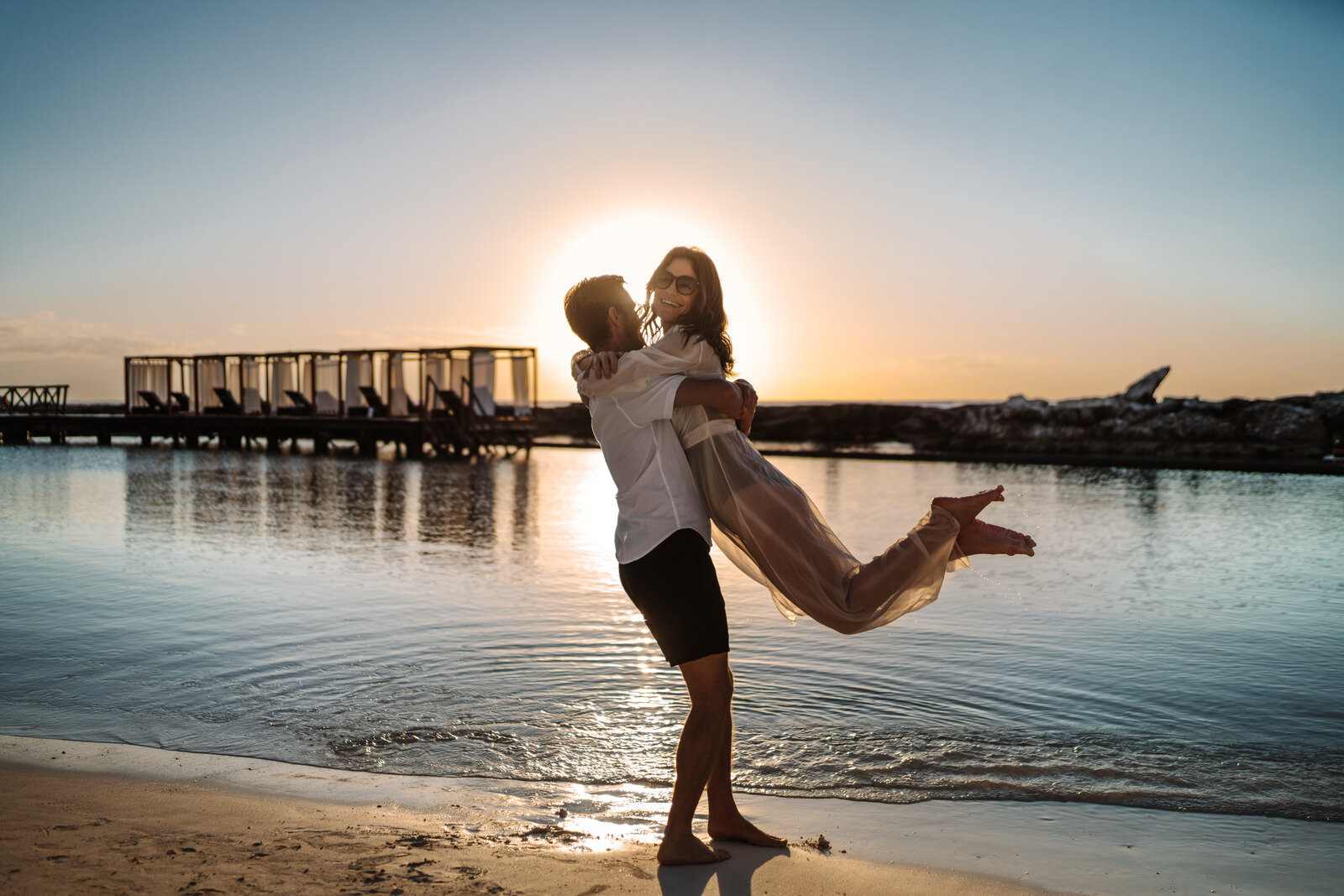 a man holding a woman on a beach