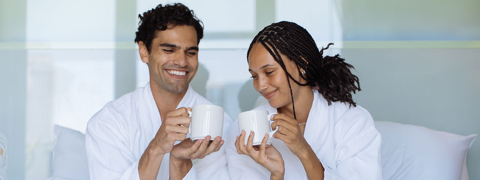 a man and woman in bathrobes holding cups